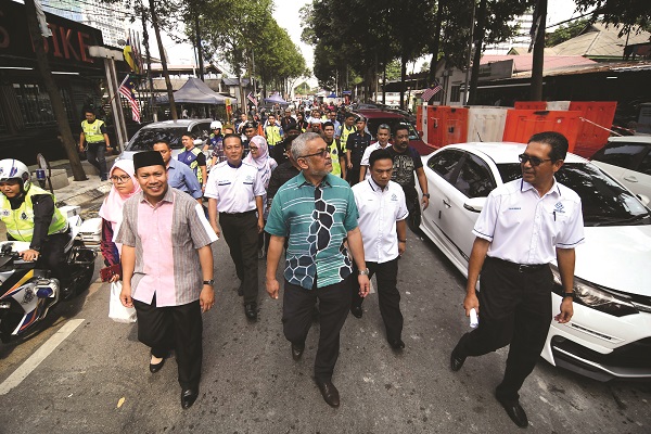 KHALID (depan) bersama Zulkurnain (kanan) meninjau keadaan Kampung Baru.