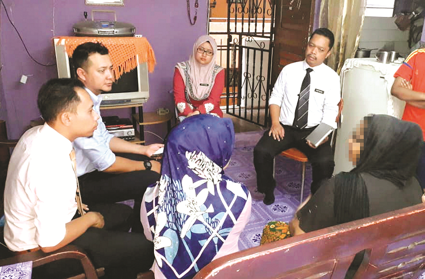 MOHD SHAHRIZZAT (dua dari kiri) bersama pegawai PPD mendengar masalah seorang pelajar perempuan yang tercicir daripada sekolah ketika membuat lawatan ke rumah keluarganya di Kuala Lumpur baru-baru ini.