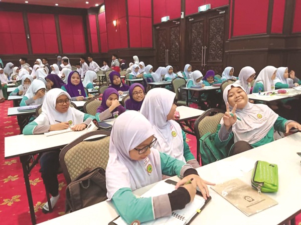SEBAHAGIAN murid-murid Tahun Lima SRA Ibnu Khaldun Masjid Wilayah Persekutuan kelihatan ceria menyertai Kem Teknik Menjawab Soalan UPKK di dewan masjid berkenaan baru-baru ini.
