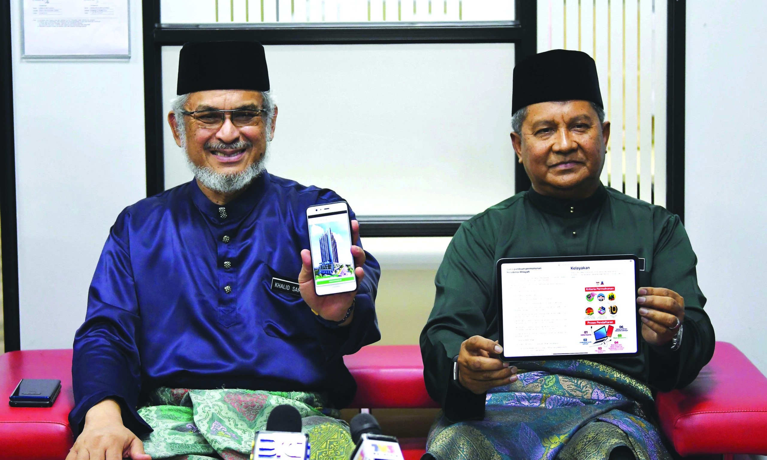 KHALID (kiri) dan Saripuddin menunjukkan aplikasi untuk orang ramai memohon rumah Residensi Wilayah secara atas talian pada Majlis Perhimpunan Bulanan Kementerian Wilayah Persekutuan di Putrajaya baru-baru ini.