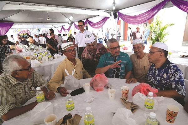 KHALID (tengah) beramah mesra dengan penduduk Kampung Baru selepas majlis pra pelancaran Town Hall bersama pemilik tanah baru-baru inii.