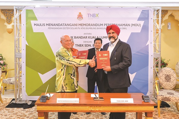 NOR HISHAM (kiri) bertukar dokumen dengan Nirinder Singh selepas menandatangani MoU antara DBKL dan TNBX di bawah program pemasangan sistem solar PV di atas bumbung bangunan-bangunan DBKL di Kuala Lumpur.