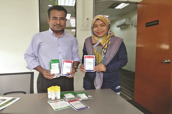 KAMARULZAMAN (kiri) bersama hortikulturis, Nor Azaz Abdul Aziz menunjukkan contoh benih bunga semusim yang diimport mencecah harga RM5,000 sepeket.