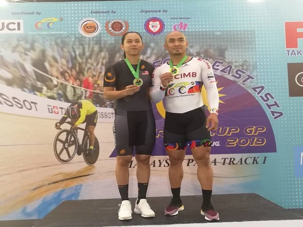 AZIZULHASNI (kanan) bersama Fatehah Mustapa meraikan kejayaan mereka selepas merangkul pingat pada Kejohanan Berbasikal Trek Asia Tenggara di Nilam, Jumaat lepas.