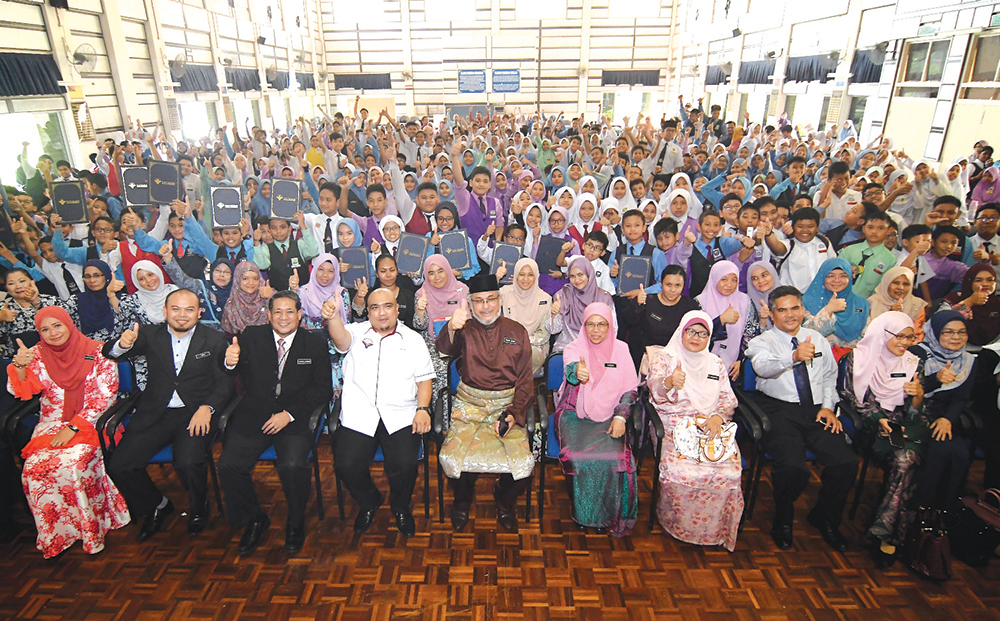 KHALID (tengah) Zaizalnizam (empat dari kiri) dan Farizah (lima dari kanan) bergambar bersama peserta Seminar Kecemerlangan UPSR Peringkat Wilayah Persekutuan selepas merasmikan program itu di SK Presint 11