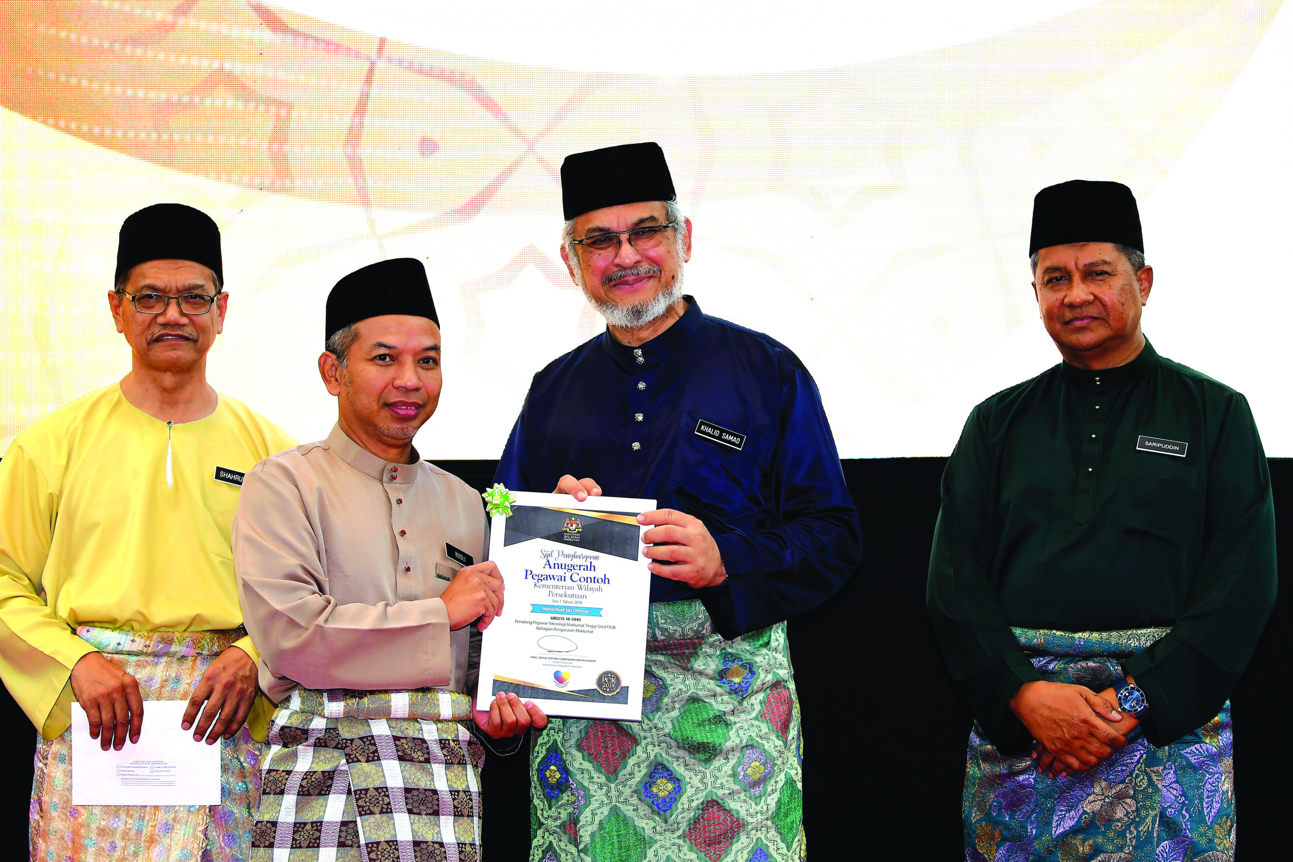 MENTERI Wilayah Persekutuan, Khalid Abd. Samad, (dua dari kanan)menyampaikan sijil Anugerah Pekerja Cemerlang.