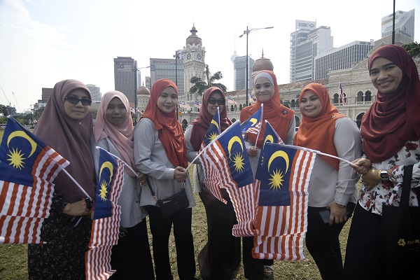 SEKUMPULAN wanita meraikan Hari Kemerdekaan dengan mengibarkan Jalur Gemilang di Dataran Merdeka, Kuala Lumpur. - Gambar hiasan