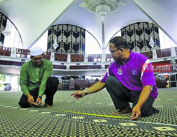 AHLI Jawatankuasa masjid menandakan kawasan jemaah dan mengikut SOP yang ditetapkan.